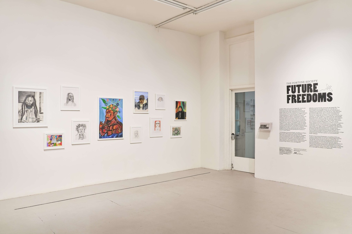 A gallery wall covered in portraits, with the title of the show, "Future Freedoms".