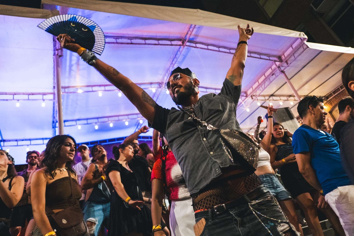 A joyful dancer flings his arms in the air at MoMA PS1's Warm Up