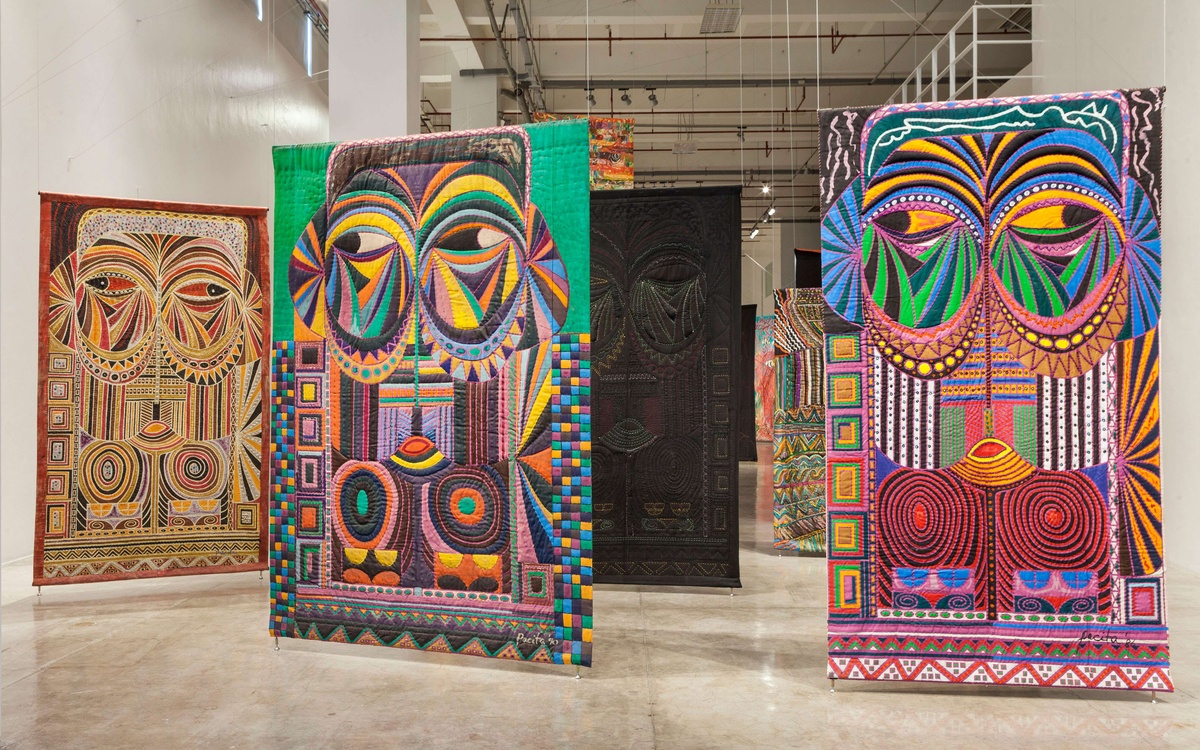 Installation view of colorful quilted works by Pacita Abad.