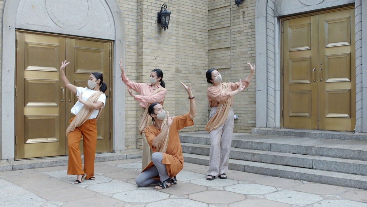 Dancers from the group Little Manila Queens raise their arms in graceful arcs.