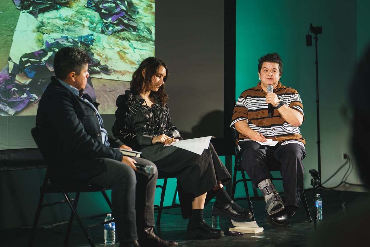 Leslie Martinez holds a mike on stage in a panel conversation at MoMA PS1