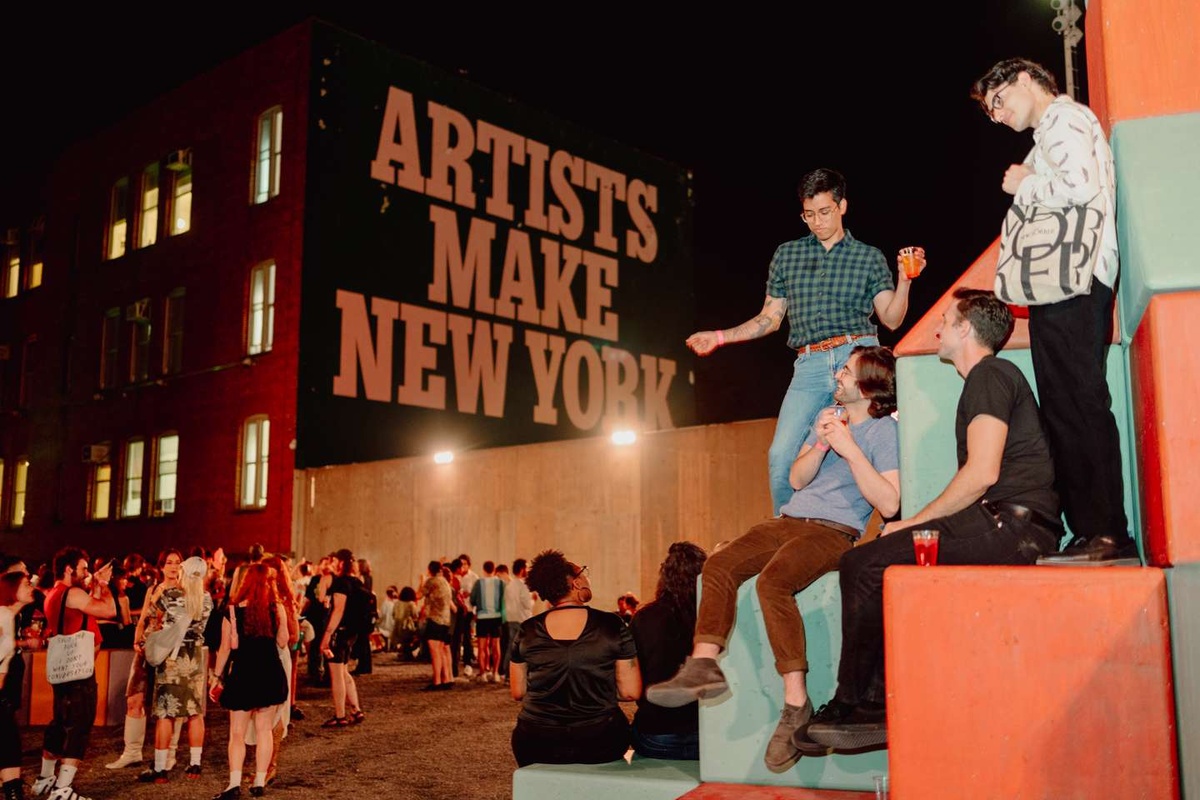 A group of people dance on Yto Barrada'a outdoor sculpture at MoMA PS1