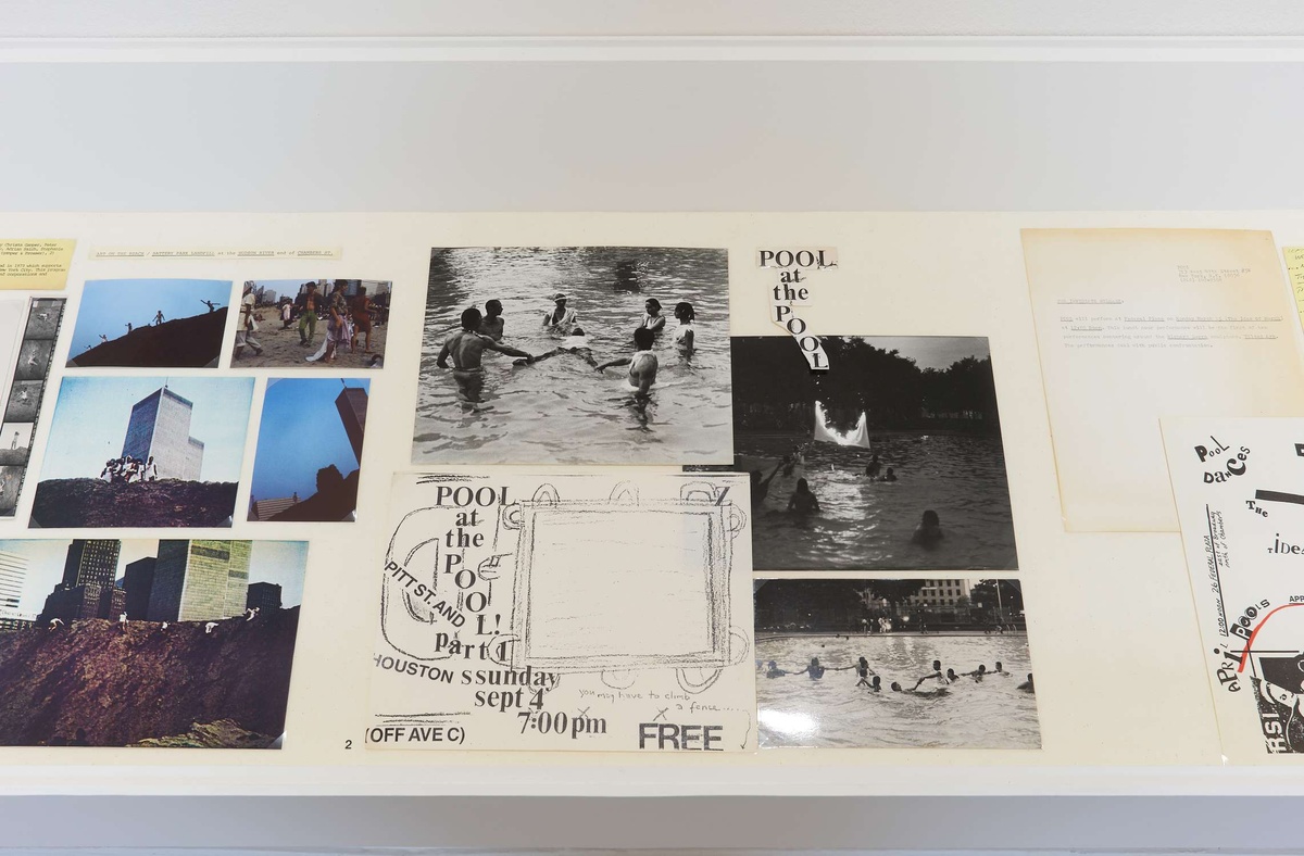 A tray of color and black & white photographs, writings, and sketches. All portraying buildings or people in pools. The word “Pool” is repeated throughout.