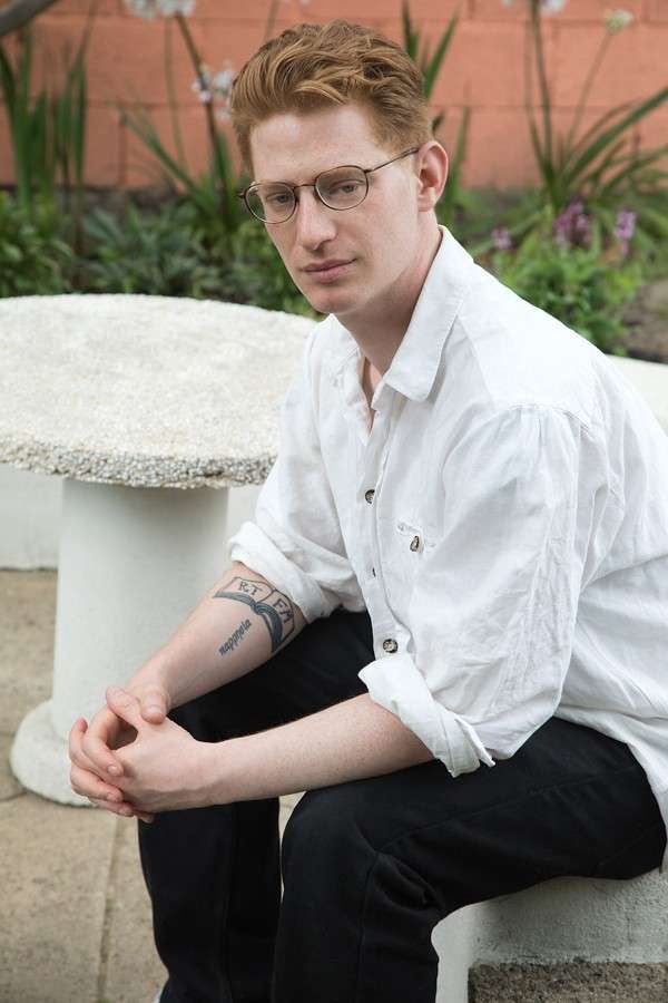 A portrait of Malcolm Harris sitting down.